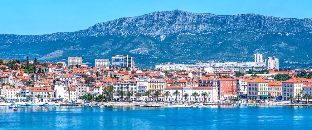 La ciudad costera de Split mostrando el contraste entre el puerto deportivo y la cordillera de Mosor, reflejando el patrimonio mediterráneo de esta sede histórica croata.
